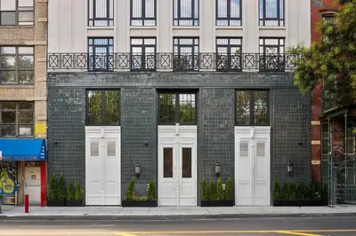 a brick building with white doors on a street at Freeman 1101 by Rove Travel - Studio with Shared Amenities in New York