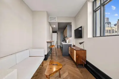 a living room with a white couch and a tv at Freeman 803 by Rove Travel - 1BR Condo with Shared Amenities in New York