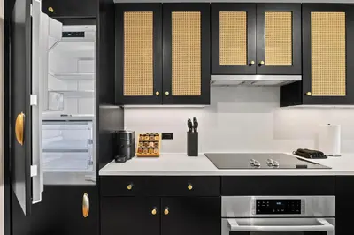 a kitchen with black cabinets and a sink at Freeman 803 by Rove Travel - 1BR Condo with Shared Amenities in New York