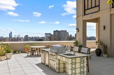 an outdoor kitchen on a patio with a view of the city at Freeman 903 by Rove Travel - 1BR Condo with Shared Amenities in New York