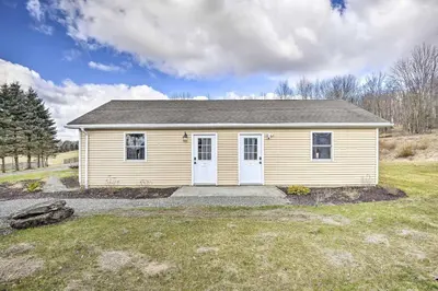 a small yellow house in a field at Cottage Complex Close to Ski Adventures in Pleasant Mount
