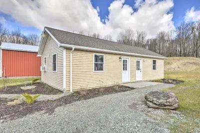 a small house with a red building in a field at Country Escape Close to Ski Resort in Pleasant Mount
