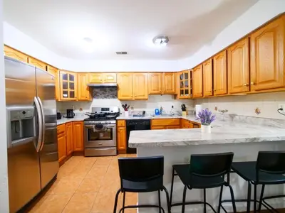 a kitchen with wooden cabinets and stainless steel appliances at Bright Private Room with Shared Bathroom near NYC in Jersey City