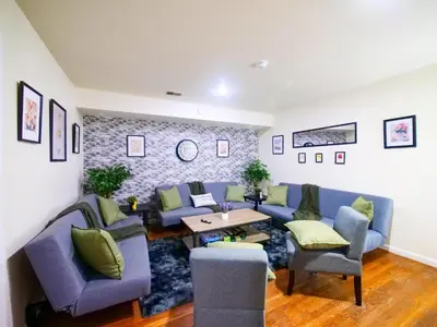 a living room with blue couches and a table at Charming Room with Shared Space close to NYC in Jersey City