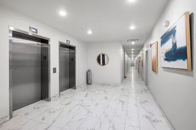 a hallway with white walls and silver doors and marble floors at Luxury 1BR Getaway - Modern Stylish & Great Area in Philadelphia