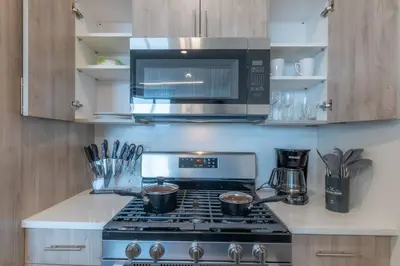 a kitchen with a stove top oven with a microwave at Smoked Amber Stay, Free Parking, Sleep 5, 20 percent OFF in East Orange