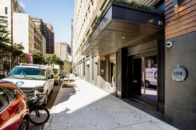 a street with cars parked next to a building at Blueground Chelsea rooftop pool nr High Line NYC-2145 in New York