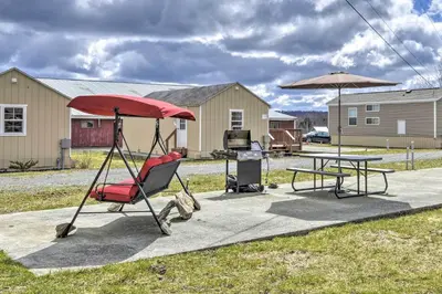 a patio with a table and a chair and an umbrella at Suite to Unwind Close to Skiing in Pleasant Mount