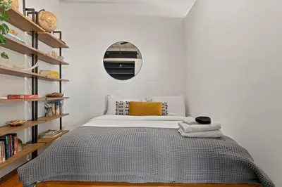 a bedroom with a bed and a round mirror at Bright 2-Bed Loft in Northern Liberties Walk to Dining, Museums in Philadelphia