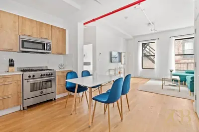 a kitchen and dining room with a table and blue chairs at Gorgeous and Fully Equipped Luxury 1 Bedroom Apt in New York