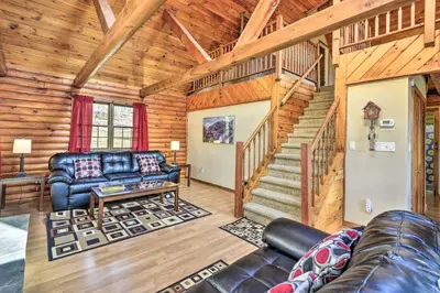 a living room with a couch and a staircase in a cabin at Log Cabin And Cottages At Equestrian House in Pleasant Mount