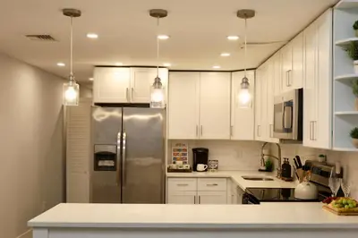 a kitchen with white cabinets and a stainless steel refrigerator at Modern Lakeview Escape | Scenic Deck • Fire Pit in Monroe