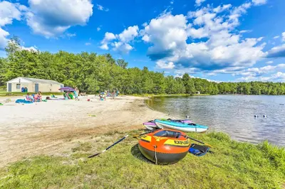 two boats sitting on the shore of a beach at Waterfront Arrowhead Lake Retreat with Resort Perks! in Pocono Lake
