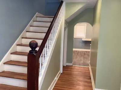 a hallway with a staircase with white and wood floors at Pleasant, Comfortable PR Near Vestal NY in Johnson City