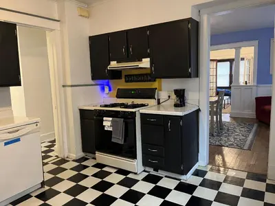 a kitchen with black appliances and a checkered floor at NightShiftReady Binghamton Trades Nurses Welcome Private Room in Shared Apartment in Binghamton