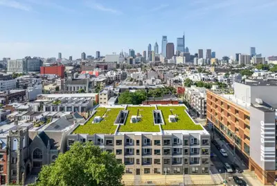 a building with a green roof with a city in the background at Modern 1BR1BA unit at Fairmount Square in Philadelphia