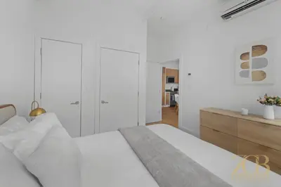 a white bedroom with a bed and a dresser at 517 - 47C Beautifully Renovated 1 bedroom in Prime Manhattan in New York