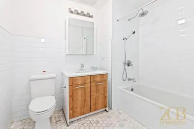 a white bathroom with a toilet and a sink and a tub at 517 -41D Gorgeous and Fully Equipped Luxury 1 Bedroom Apt in New York