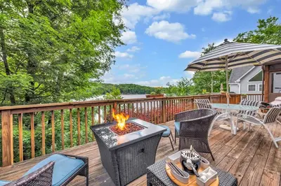 a patio with a fire pit on a deck at Lakefront Views 5 Bdrm Kayaks Out Kitchen in Lake Ariel
