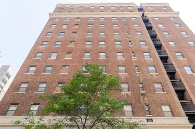 a tall brick building with a tree in front of it at Blueground Murray Hill view nr Empire State NYC-1911 in New York