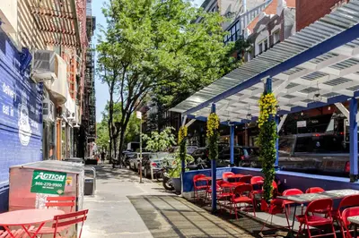 a sidewalk with tables and chairs on a street at Blueground Nolita view nr Washington Square NYC-2051 in New York