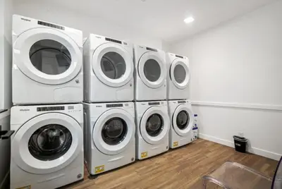 four washers and dryers are lined up in a room at Cozy 1BR Apartment in Philly Prime Location in Philadelphia