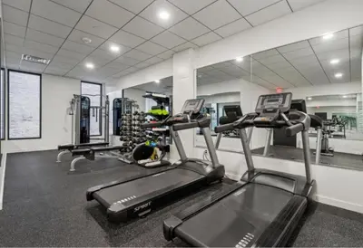 a gym with two tread machines and a mirror at Bright urban studio, fully furnished in Philadelphia