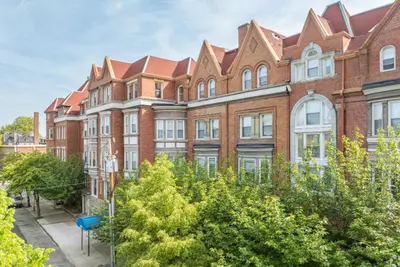 a large brick building with trees in front of it at Carriage House Stylish 1BR Retreat in Philadelphia