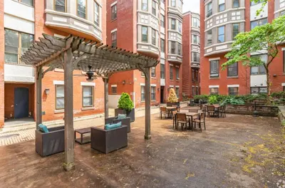 a courtyard with tables and chairs and a wooden pergola at Cozy, Modern Living at Carriage House in Philadelphia