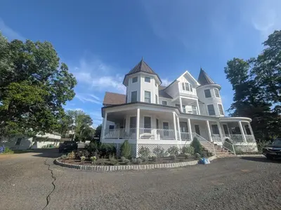 a large white house with a turret at Parkway House Goshen Bed And Breakfast Suite 1 in Goshen