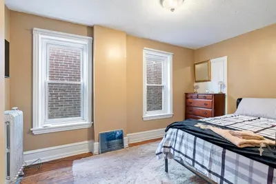 a bedroom with a bed and a dresser and two windows at The Serenity Manor in Chester