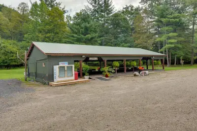 a large green building with a porch on a field at Deluxe Cabin D at Elk Creek Escape! Pets Welcome in Hillsgrove