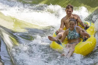 a man and a woman on a raft in the water at Private 10 guest Getaway Fire-Pit Golf Hike Ski Spa in Vernon