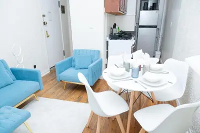 a dining room with a white table and blue chairs at Elegant84 West Side Home 5 min to Central Park in New York