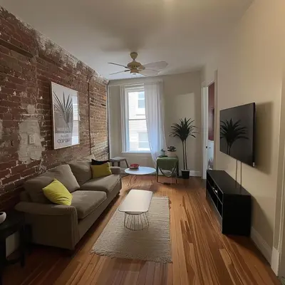 a living room with a couch and a brick wall at The Helton Suites at Midtown in New York