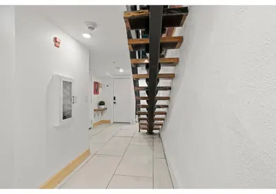 a hallway with white walls and wooden stairs at Fairmount Park GSN Soil 2 in Philadelphia