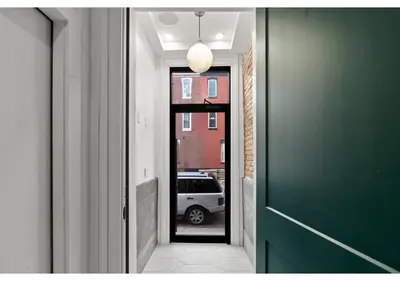 a hallway with a green door and a car outside at City Ave GSN Vine 1 in Philadelphia