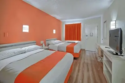 a hotel room with two beds and a flat screen tv at Value Extended Stay in Maple Shade