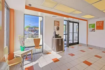 a lobby with a waiting room with a table and chairs at Value Extended Stay in Maple Shade