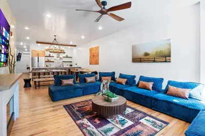 a living room with blue couches and a kitchen at Summit Stay Near Kalahari & Raceway in Pocono Summit