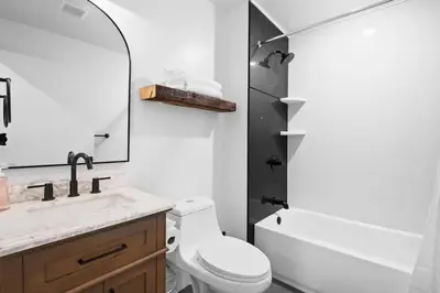 a bathroom with a toilet and a sink and a mirror at Summit Haus Cozy Getaway in the Poconos in Pocono Summit