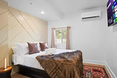 a bedroom with a large bed with a wooden headboard at Pocono Summit Lodge Game Room & Family Fun in Pocono Summit