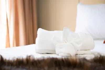 a pile of towels sitting on top of a bed at The Grand Pocono Getaway Waterparks & Raceway in Pocono Summit