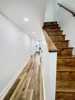 a hallway with wooden floors and stairs in a house at Comfort Philly Stay Jacuzzi and Parking in Philadelphia