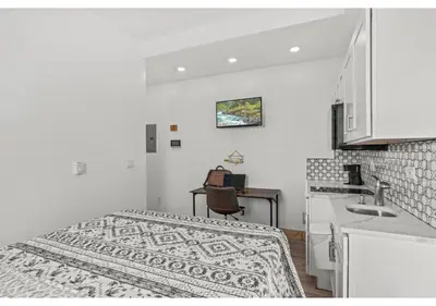 a small white room with a bed and a kitchen at Liberty bell GSN Harvest 1 in Philadelphia