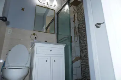 a bathroom with a toilet and a sink and a mirror at New York Private room 30 in West New York
