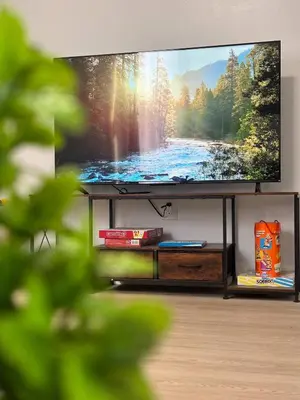 a flat screen tv sitting in a living room at Cozy 3BR Apt in Jersey City! near NYC & Metlife! in Jersey City