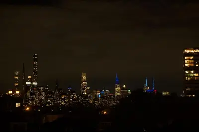 a city skyline at night with blue lights at Big Apple room 34 in West New York