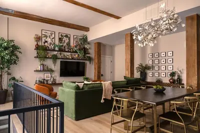 a living room with a green couch and a table at Stunning Artisan Loft Chic & Modern - The Botanist in Philadelphia
