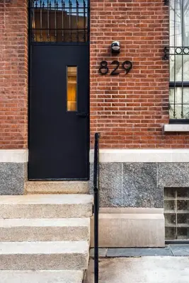 a black door on the side of a brick building at Luxurious Artisan Loft w Chic Design - The Tanner in Philadelphia